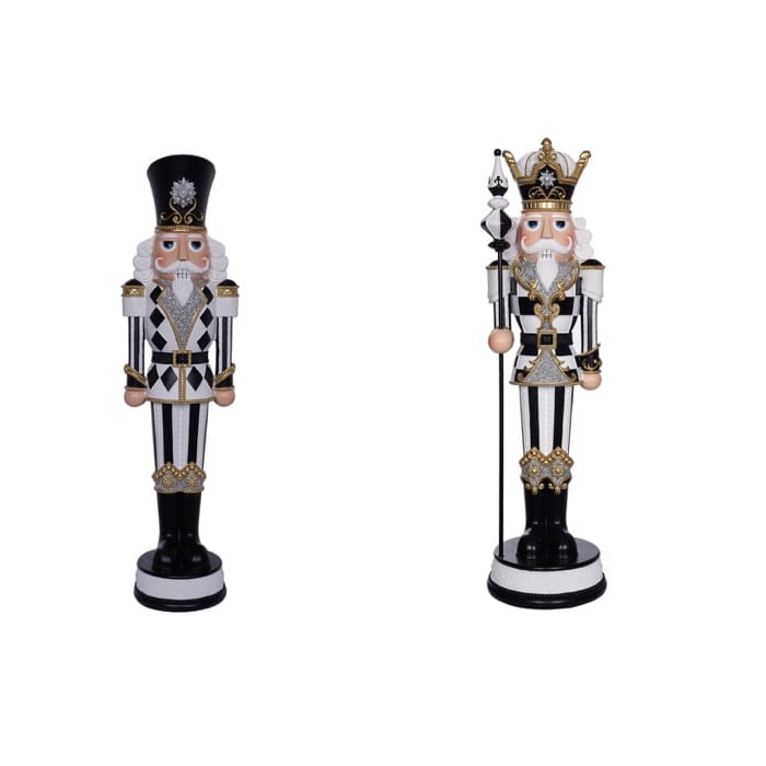 Two decorative nutcracker figurines in black, white, and gold, one with a crown holding a scepter