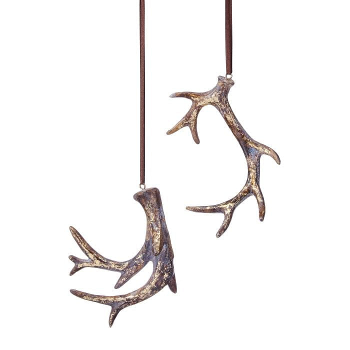 Two resin deer antler ornaments with gold distressed finish hanging from brown leather cords