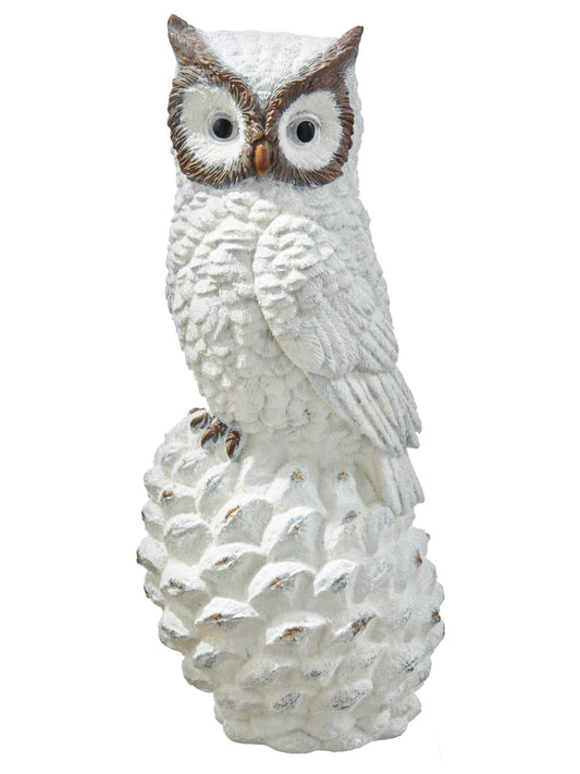 White resin owl figurine with brown facial details perched atop a large pinecone base