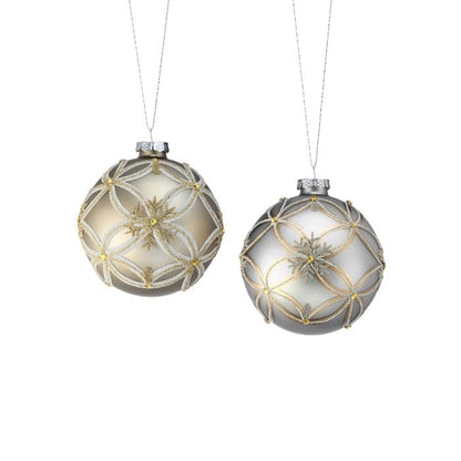 Two matte glass ball ornaments with glitter snowflake and lattice patterns in gold and silver tones