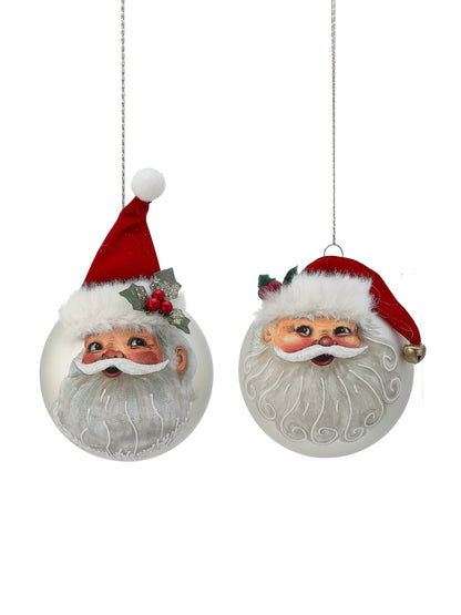 Two round glass Santa face ornaments with red felt hats, white fur trim, and holly accents