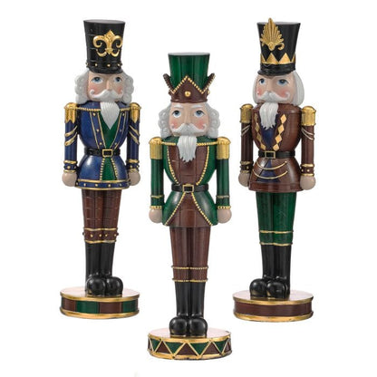 Set of three decorative resin nutcracker figurines in blue, green, and brown with gold trim