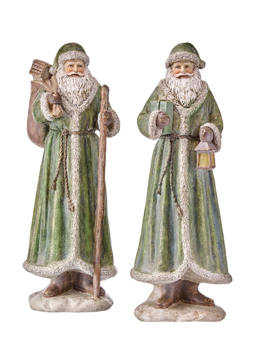 Two antique-style Santa Claus figurines in green robes, one holding a staff and sack, one holding a lantern