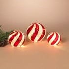 Three lighted red and white candy stripe mercury glass spheres in graduated sizes