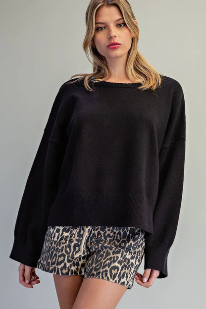 Oversized black crewneck knit sweater with wide sleeves and ribbed cuffs