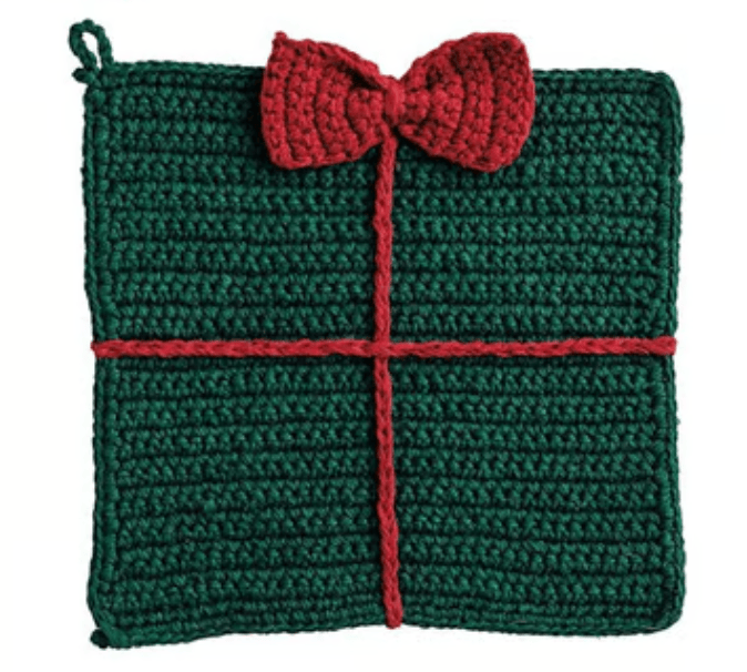 Square crocheted trivet designed as a Christmas gift with red bow and ribbon detail