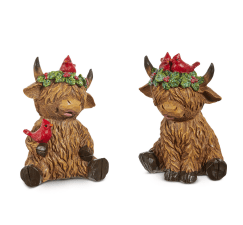 Two brown highland cow figurines with cardinal birds and holly berry wreaths