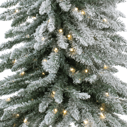 Flocked alpine artificial Christmas tree with warm white LED lights and snow dusting