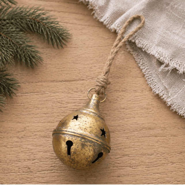Antique gold metal jingle bell ornament with star cutouts and jute rope hanger
