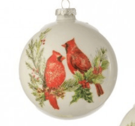 White glass ball ornament with two red cardinals and holly branches