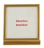 Gold metal and glass frame with easel displaying red 'Sweater Weather' text