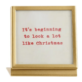 Gold metal frame with glass displaying red typewriter text Christmas holiday saying