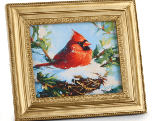 Framed painting of red cardinal perched on snowy pine branch, gold frame