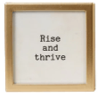 Gold-framed glass magnet with black text reading Rise and Thrive