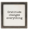 Small square metal and glass framed magnet with black text reading Gratitude changes everything