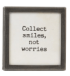 Small black framed magnet with white text reading Collect smiles not worries