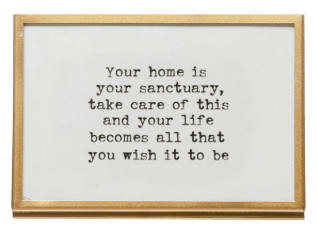 Gold wooden frame with easel displaying black typewriter-font inspirational home sanctuary quote