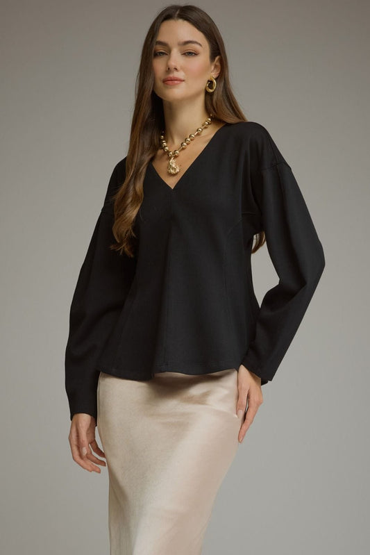 Black V-neck long sleeve top with curved seams and balloon sleeves paired with satin skirt