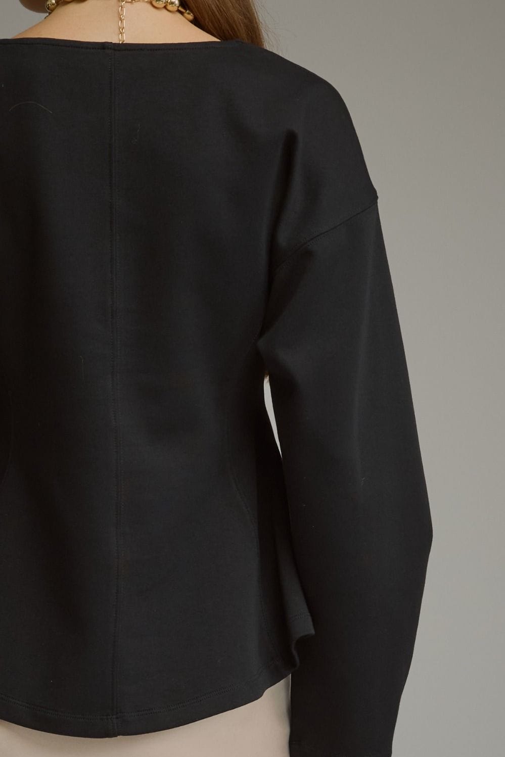 Entro black long sleeve top with curved hem and dropped shoulders, back view