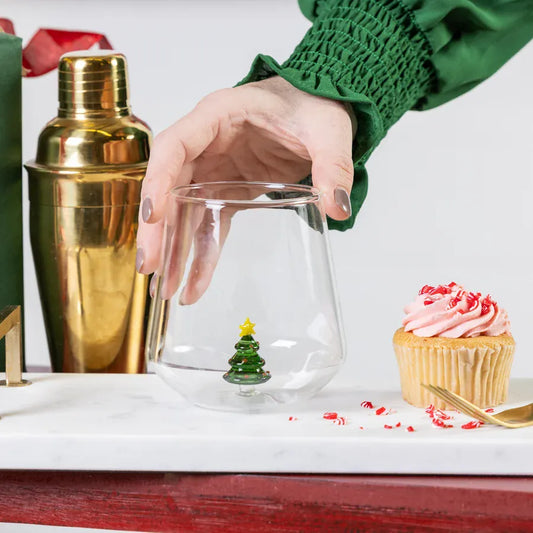 Clear stemless wine glass with miniature glass Christmas tree figurine inside
