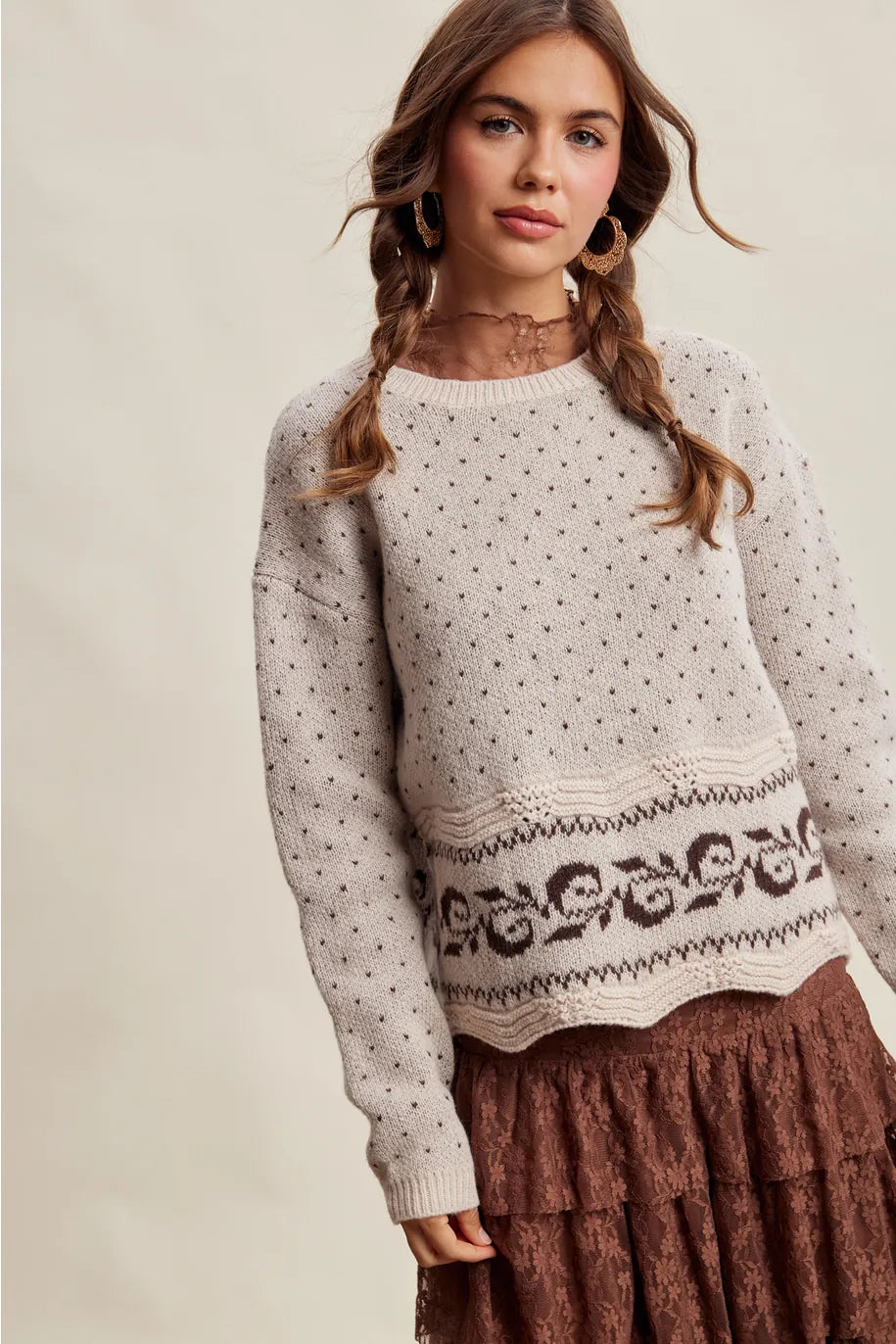 Cream knit sweater with dark Swiss dot pattern and scrollwork border hem