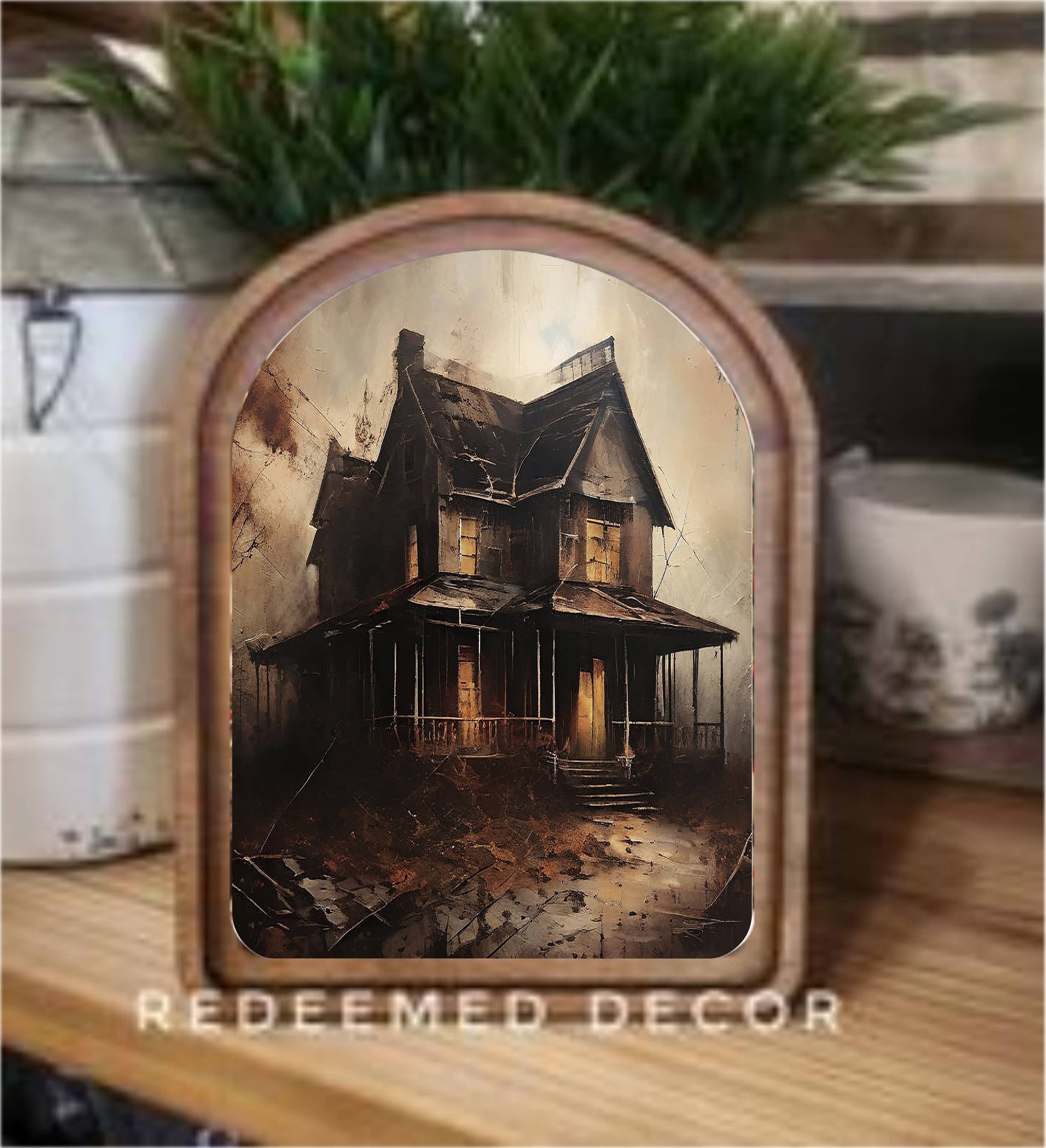 Arch-top wood framed canvas art of a dark haunted house with glowing windows