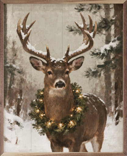 Framed wall art painting of a whitetail deer wearing a lit Christmas wreath in snowy forest