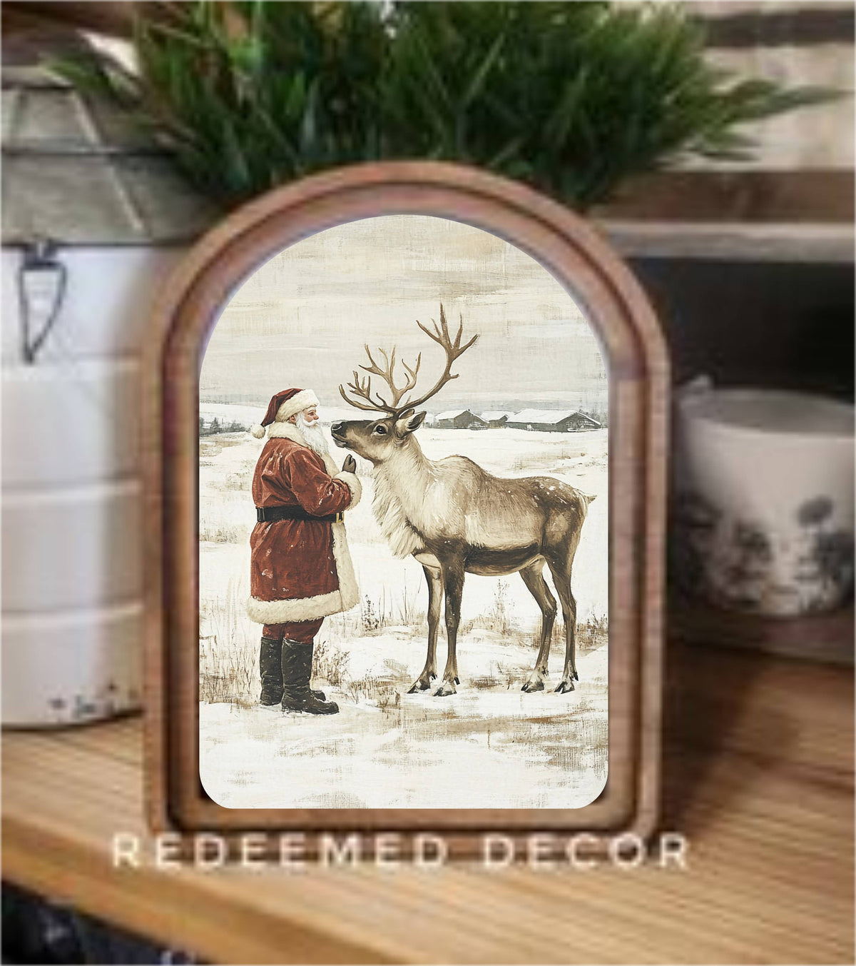 Arched wood-framed art print of Santa Claus with reindeer in snowy winter landscape