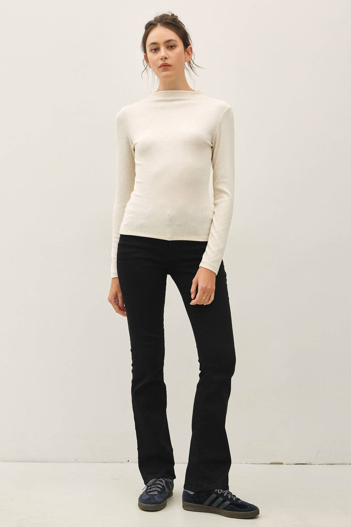Cream ribbed mockneck long sleeve fitted knit top worn with black flare pants