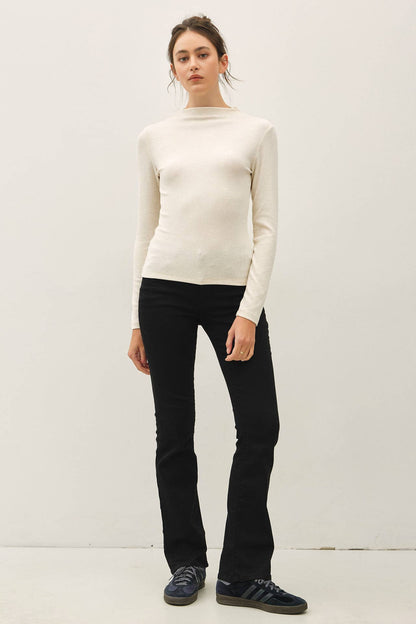 Cream ribbed mockneck long sleeve fitted knit top worn with black flare pants