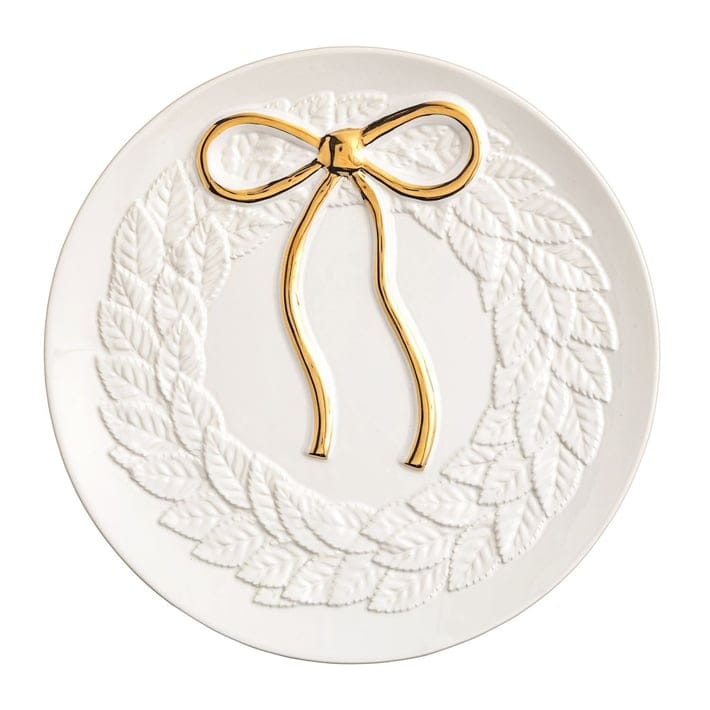 Round white ceramic plate with embossed leaf wreath and gold metallic bow detail, top view