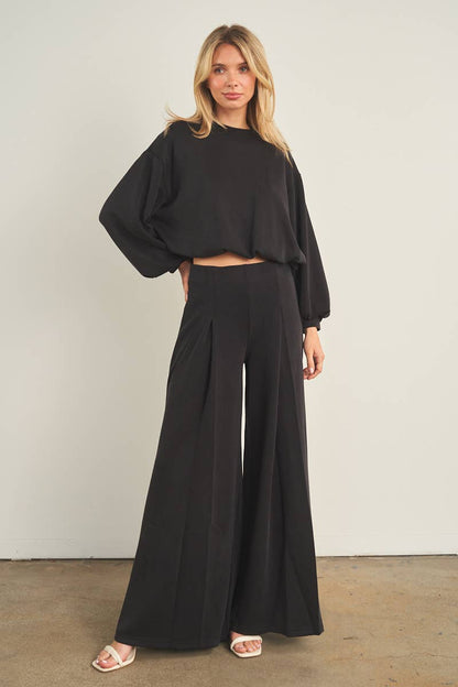 Black wide-leg palazzo pants with high waist and pleated front detail