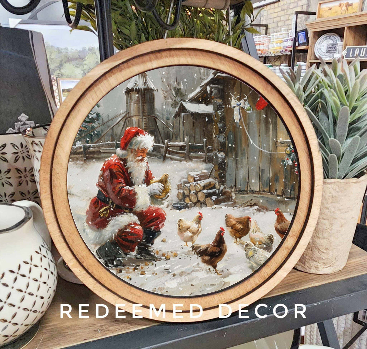 8-inch round wood-framed canvas art of Santa Claus feeding chickens in a snowy farmyard