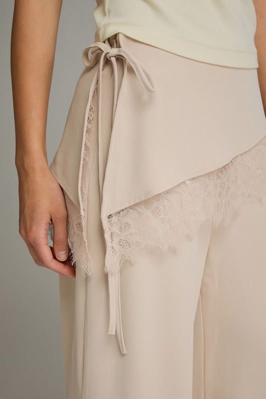Beige wide-leg pants with lace trim overlay and self-tie side bow detail
