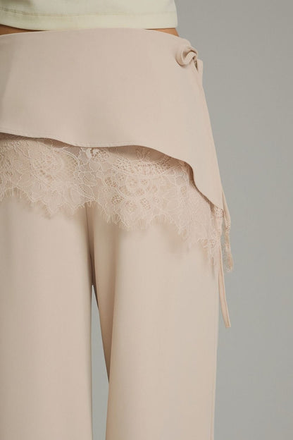 Beige wide-leg pants with wrap overlay and floral lace trim detail