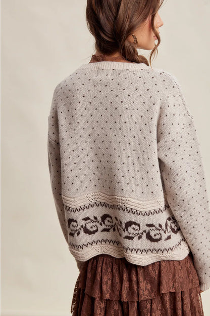 Light gray knit sweater with dot pattern and dark floral border hem detail