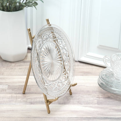 Satin gold metal plate easel displaying clear embossed glass plate on wood surface