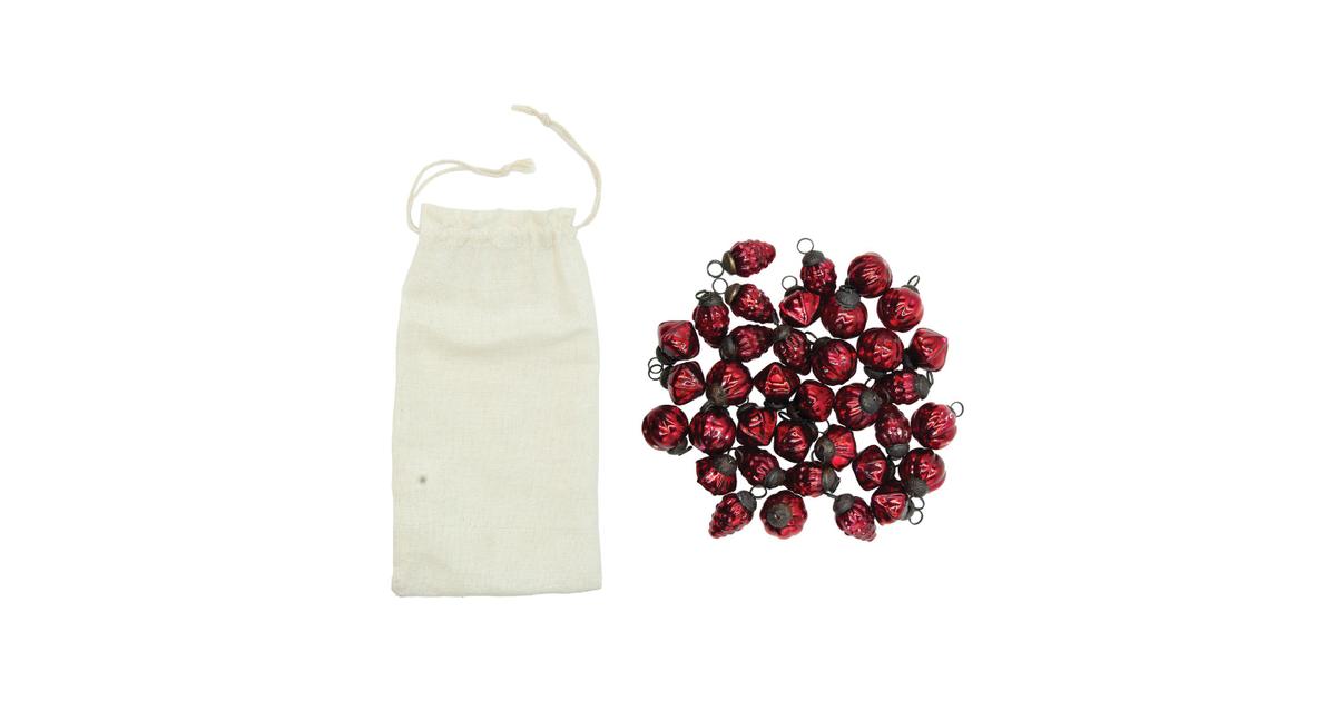 Set of 36 small red embossed mercury glass ornaments beside a drawstring muslin bag
