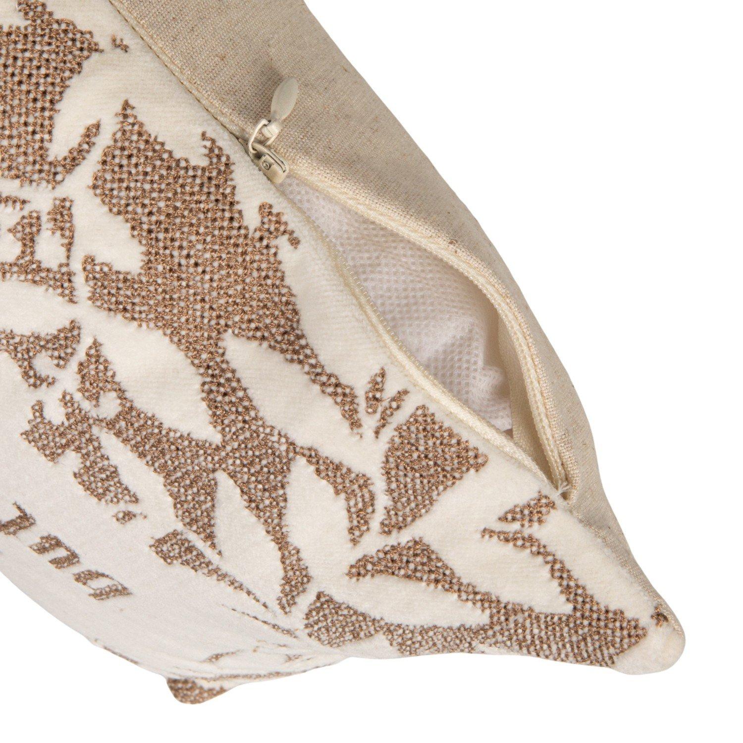 Close-up of decorative pillow back with zipper closure and embroidered botanical leaf pattern