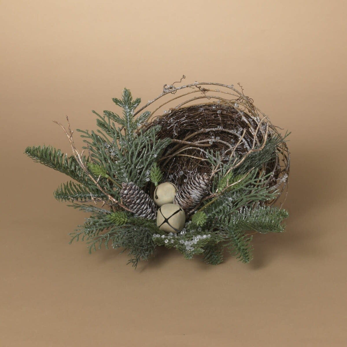 Twig bird nest with jingle bells, pinecones, and frosted evergreen branches, top-angle view