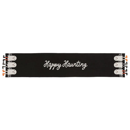 Black Halloween table runner with white ghost figures and dangle legs on each end, 'Happy Haunting' script center