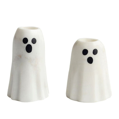 Set of two white marble ghost-shaped taper candle holders with black oval eyes and mouths
