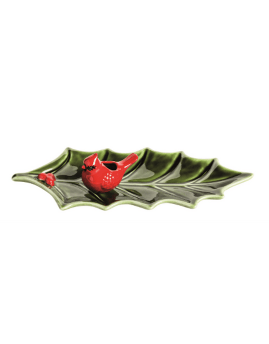 Ceramic holly leaf-shaped tray with red cardinal bird figurine and red berries, top angle view
