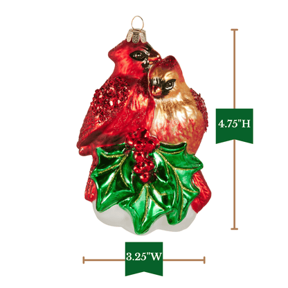 Glass Christmas ornament featuring two cardinals perched on shiny holly leaves with red berries