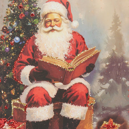 Rectangular ornament with vintage Santa reading a book beside a decorated Christmas tree with glitter details