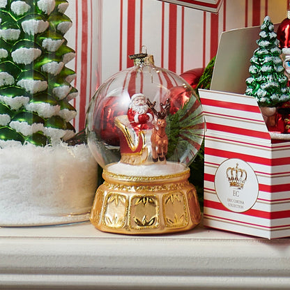 Clear glass globe ornament with Santa sleigh scene inside, gold decorative base