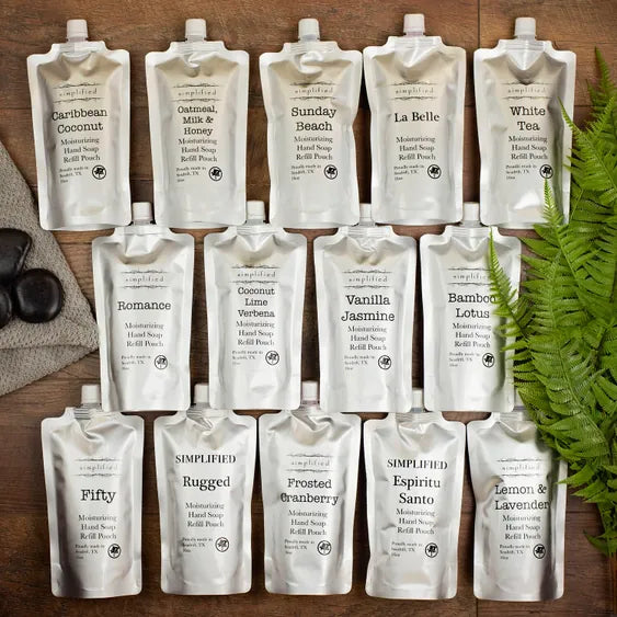 White 16 oz hand soap refill pouches in various scents on wood surface