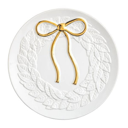 Round white ceramic plate with embossed leaf wreath and gold metallic bow on top