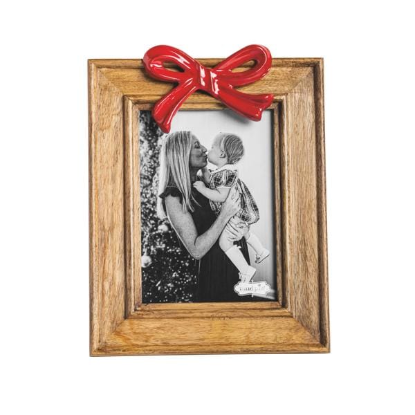 Rectangular wood picture frame with red ceramic bow on top, holding black and white photo