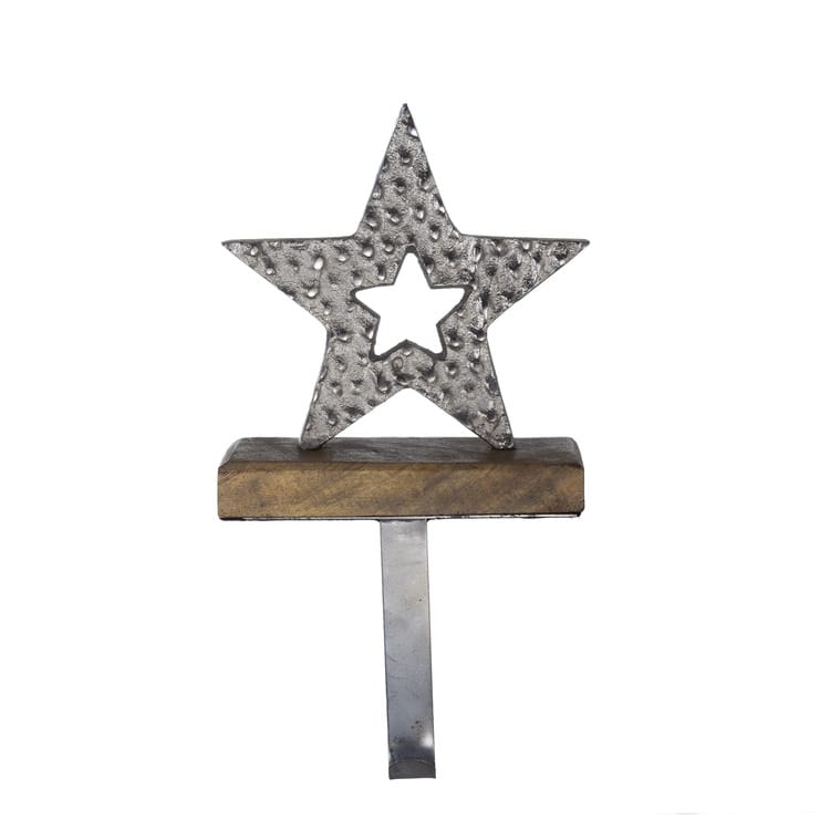 Hammered metal star stocking holder with cutout star center on a wooden base with hook
